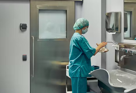 healthcare worker washing hands in facility