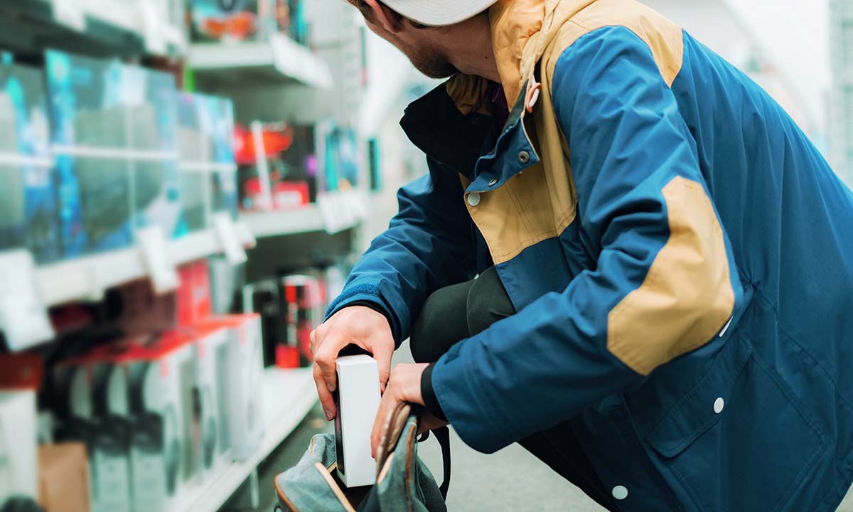 Person Shoplifting in a store - adding something to their bag. 